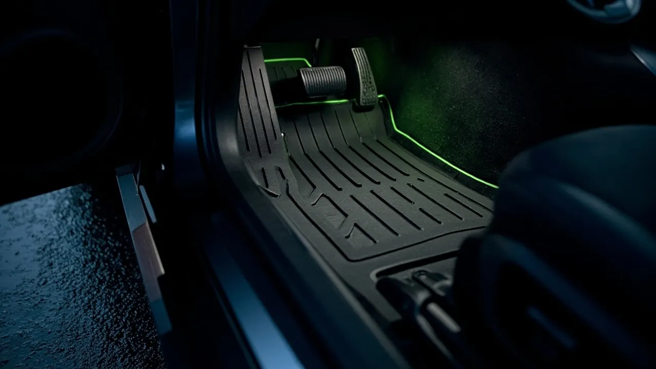 Custom-fit black TPE floor liners installed in the driver footwell of a Tesla Model 3 Highland